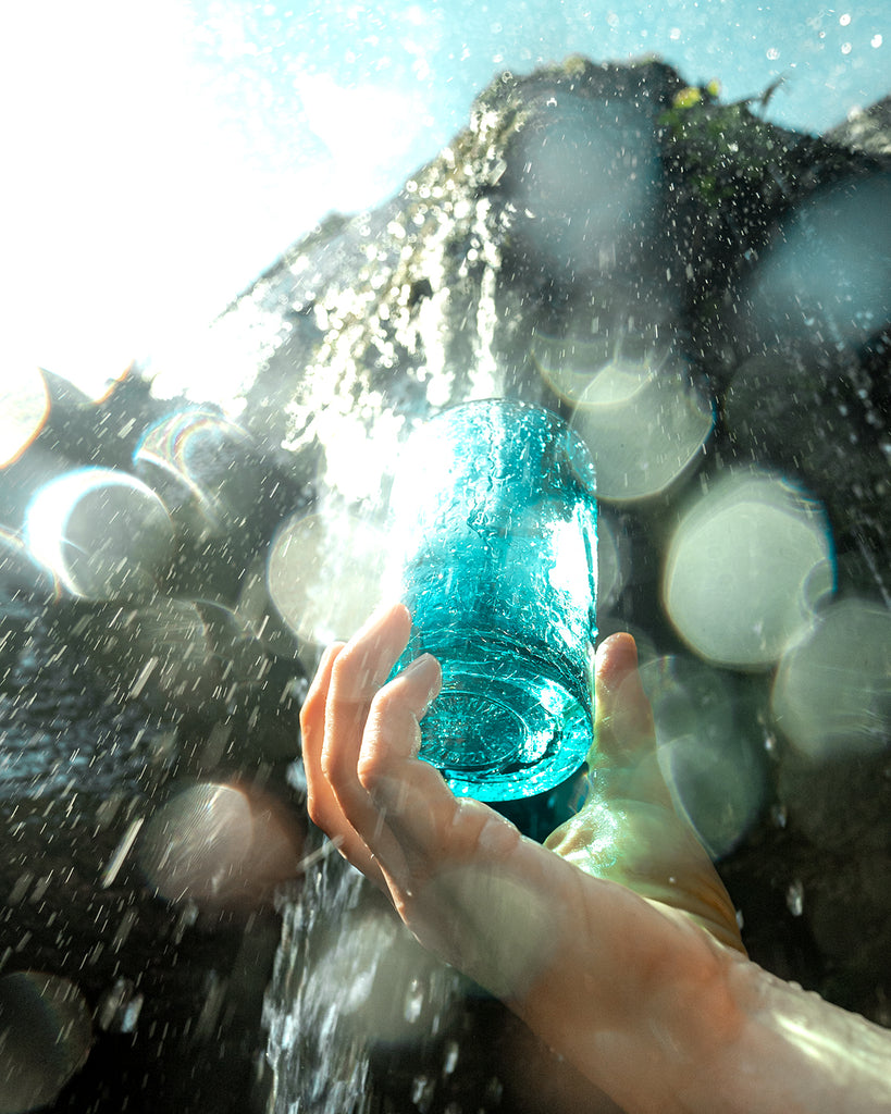 Handblown Glass Cup being held under a waterfall